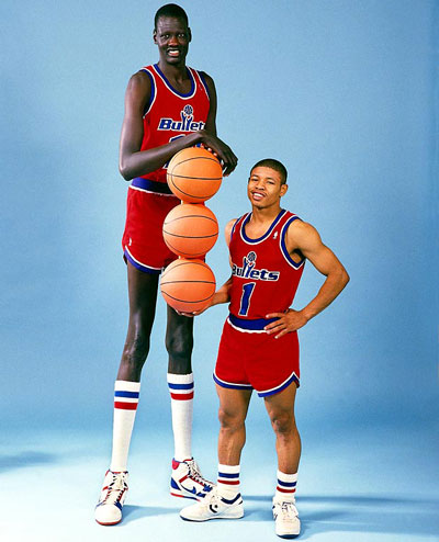 Tyrone Bogues junto a Manute Bol, dos de los jugadores más bajos y altos de la historia de la NBA.