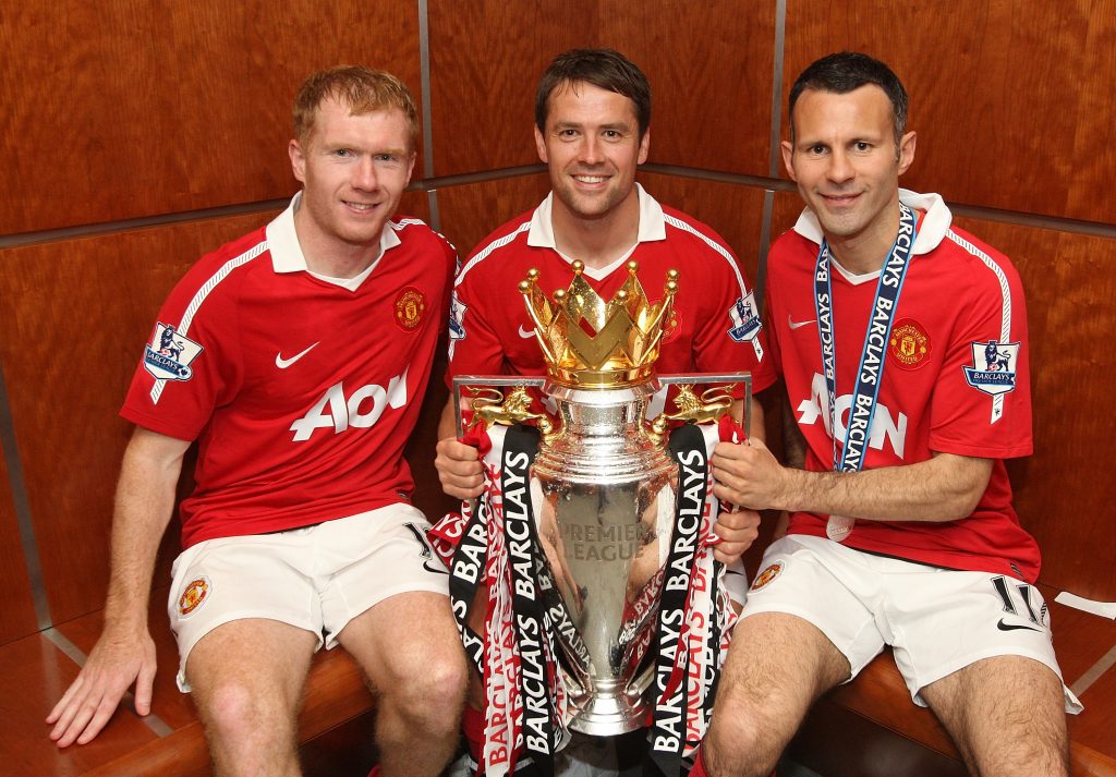 Michael Owen posa con el trofeo de la Premier League en compañía de dos leyendas del Manchester United: Paul Scholes y Ryan Giggs